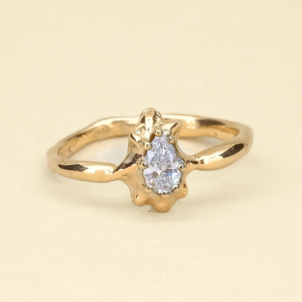 Diamond star ring, an organic cast gold band with a pear-shaped diamond