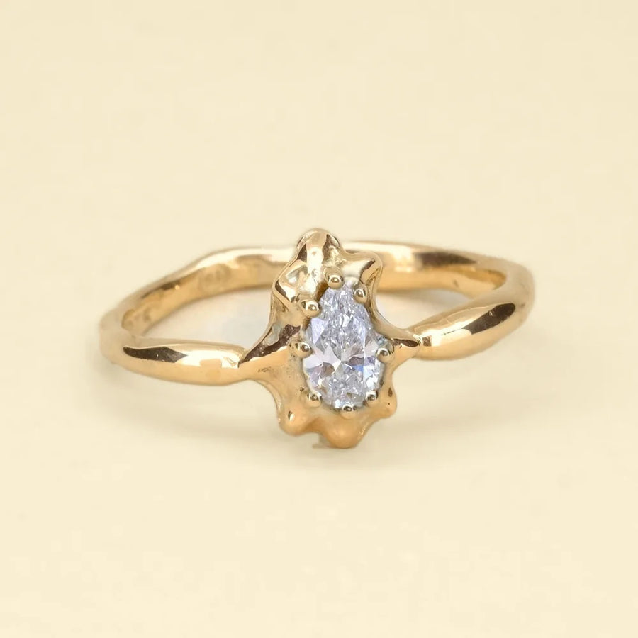 Diamond star ring, an organic cast gold band with a pear-shaped diamond