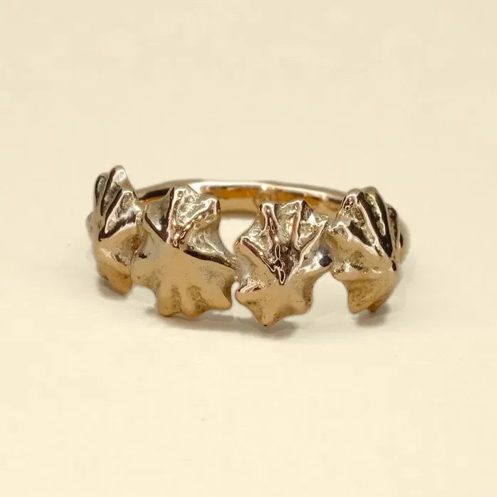Star Limpet ring, a gold ring of four cast limpet shells, on cream velvet