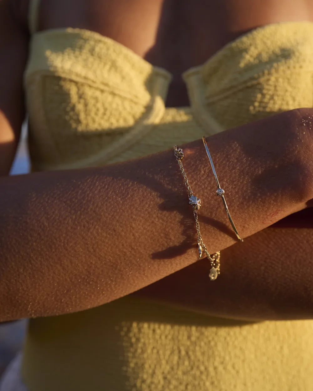 Gold limpet shell bracelet worn on the wrist in evening light