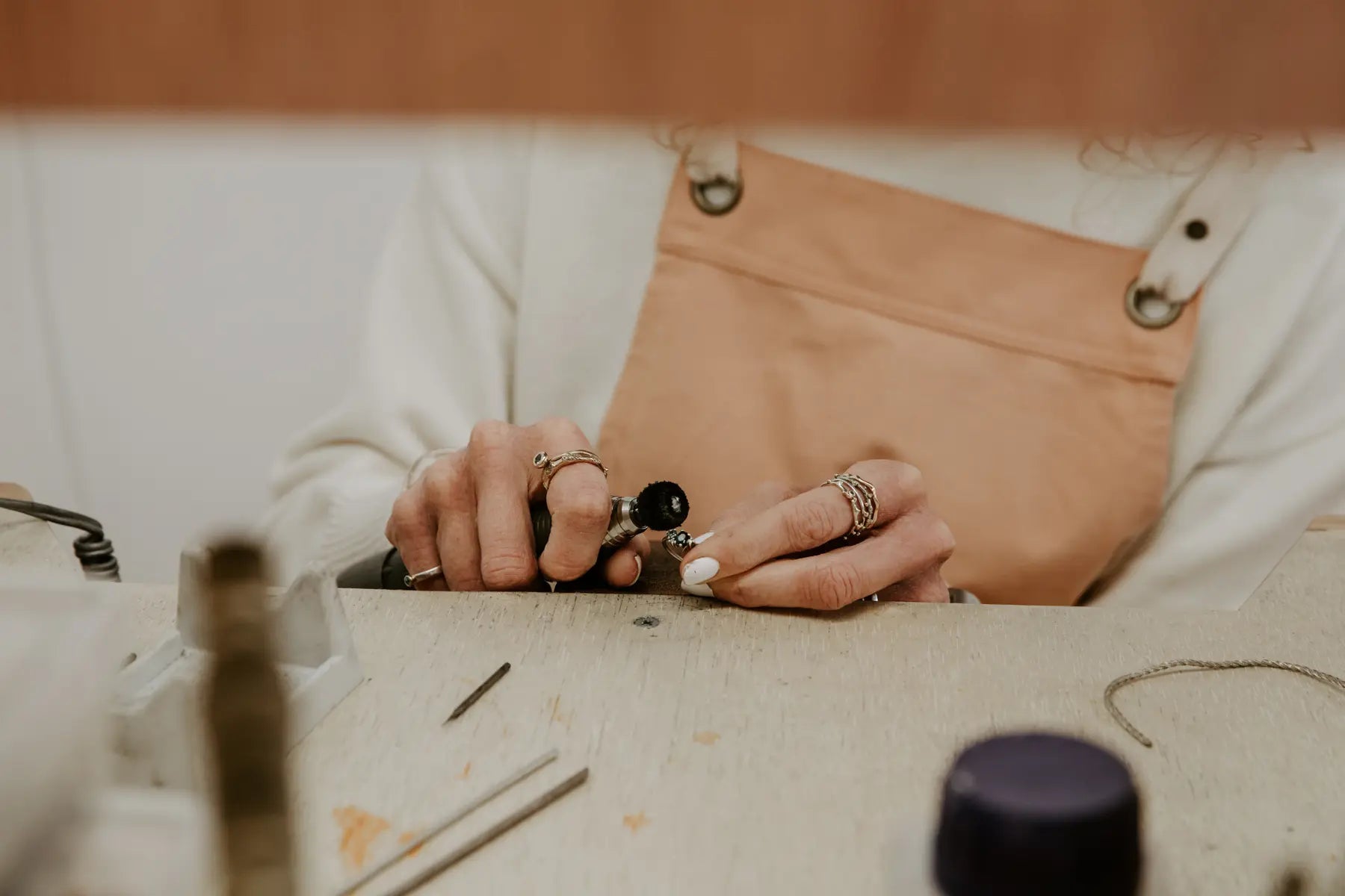Sophie at the bench, polishing a stone-set ring