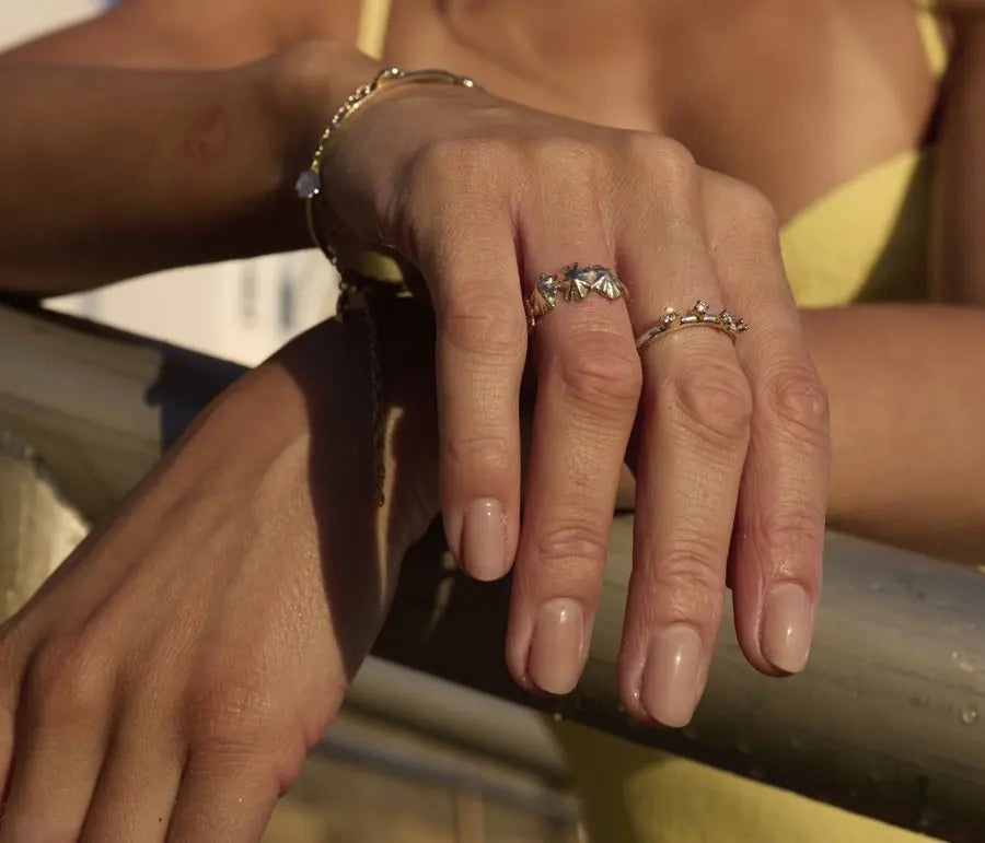 Hands resting on a railing, wearing the four shell ring